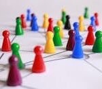 A strategic arrangement of colorful pawns connected on a game board, symbolizing networking and teamwork.